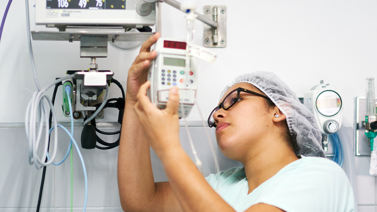 A biomedical engineering technician sets up a medical device in a hospital room.